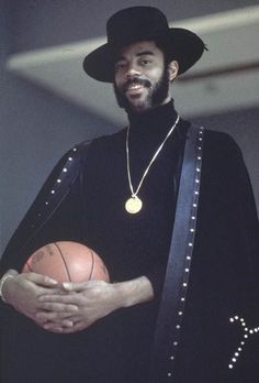 a man in a black outfit holding a basketball