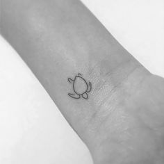 a small tattoo on the wrist of a person's arm with a cat design