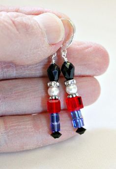 "These cute and sparkly earrings are handcrafted by me. I use jet, sapphire and light siam Swarovski crystals highlighted with Bali sterling silver and swarovski crystal rondells. The nutcracker's head is a Swarovski crystal white pearl. Lever back ear wires are sterling silver. Earrings hang approximately 1 1/4\" from ear wires. Would make a great addition to your holiday jewelry! Please check out my other unique designs! http://www.etsy.com/shop/LeaningTreeDesigns Handmade by me in my smoke-fr Nutcracker Earrings, Christmas Light Earrings, Earrings 2024, Bloodstone Jewelry, Bloodstone Necklace, March Birthstone Necklace, Christmas Gifts For Teen Girls, Unique Handcrafted Jewelry, Holiday Earrings