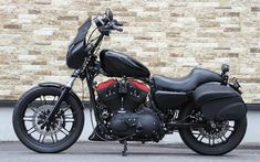 a black and red motorcycle parked in front of a brick wall