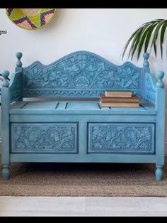 a blue bench sitting in front of a potted plant on top of a rug