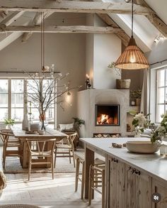 an open kitchen and dining area with wood beams on the ceiling, white counter tops and wooden chairs