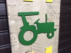 a green tractor on a wooden sign with yellow arrows