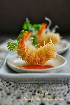 two white plates topped with food on top of a table