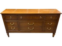 a large wooden dresser with brass handles and drawers on one side, against a white background