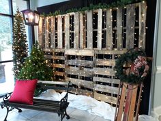 a wooden sled with christmas wreaths and lights on the wall next to a bench