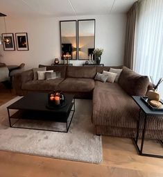 a living room filled with lots of furniture next to a large window covered in curtains