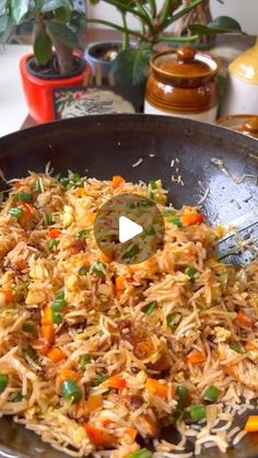 a pan filled with rice and vegetables on top of a table