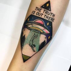 a tattoo on the arm that reads, the truth is out there with an alien flying through it