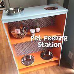 an orange pet feeding station with bowls and food