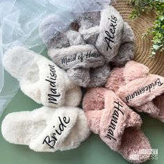 several pairs of slippers with names on them sitting next to a straw hat and plant