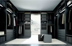 a large walk in closet with lots of black cabinets