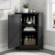 a cabinet with towels and bottles in it next to a potted plant on a table