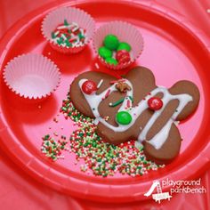 a red plate topped with a gingerbread cut out of the shape of a man