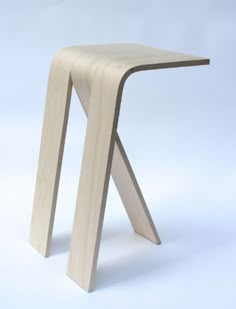 a wooden stool sitting on top of a white floor