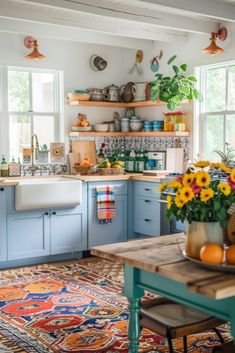 a kitchen filled with lots of blue cabinets and counter top space next to a wooden table