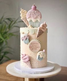 a birthday cake decorated with ice cream and cupcakes