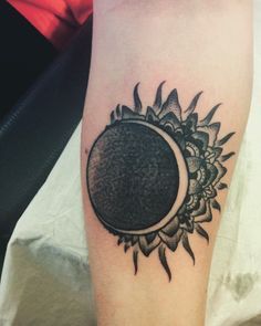 a sunflower with a half moon tattoo on the arm