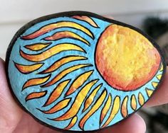 a painted rock in the palm of someone's hand