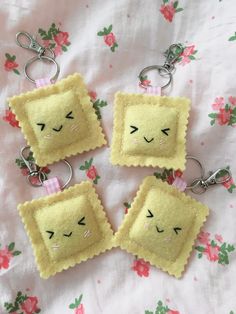 four pieces of bread with faces on them sitting on a tablecloth covered sheet and pink flowers