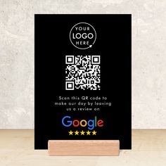 a wooden stand with a qr code on it and a google logo in the background