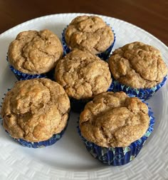 a white plate topped with muffins on top of a wooden table