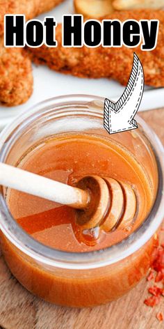 a jar filled with honey sitting on top of a wooden cutting board next to bread