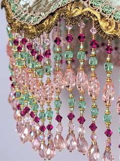 a chandelier with pink, green and gold beads hanging from it's sides