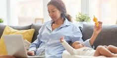 a woman sitting on a couch with a baby and laptop