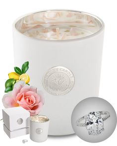 a white vase with flowers and a ring next to it, surrounded by other accessories