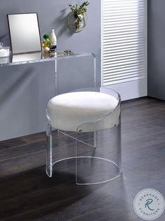 a white vanity with a mirror and stool in front of it on a wooden floor