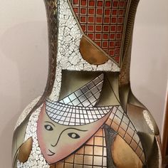 a vase that has been decorated with mosaics on it's sides and is sitting on a table