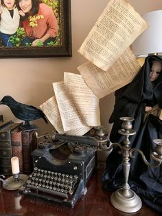 an old fashioned typewriter sitting on top of a table next to a framed photo