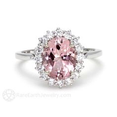 a pink and white diamond ring with diamonds around it's center stone, set in 18k white gold