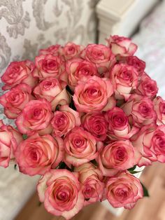 a bouquet of pink roses sitting on top of a table