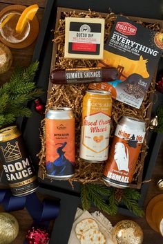 an assortment of beer and crackers in a gift box with pine cones, orange slices, cinnamon sticks, christmas decorations