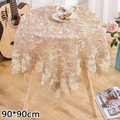 an image of a table cloth with flowers on it and a guitar in the background