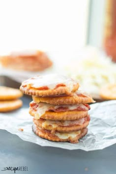 a stack of pancakes sitting on top of a piece of wax paper next to crackers