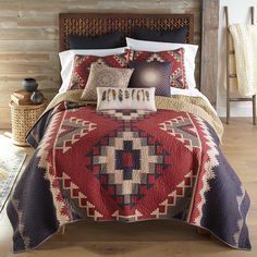 a bed with a red and blue quilt on it