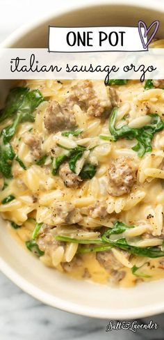 one pot italian sausage orzo with spinach in a white bowl on a marble table