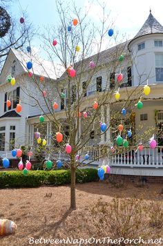 a large white house with lots of balloons hanging from it's front porchs