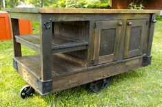 an old wooden cart sitting in the grass with wheels on it's sides and doors open