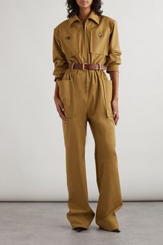 SAINT LAURENT's jumpsuit debuted as the opening look on the brand's Spring '24 runway - the utilitarian-inspired collection pays homage to pioneering female aviators. Modeled on flight suits, it's made from crisp cotton-twill for a relaxed fit and has oversized chest pockets and a detachable belt so you can cinch the waist. Take cues from the show's styling and wear yours with statement jewelry. Jumpsuit Work Outfit, Ysl Jumpsuit, Vogue 2024, Flight Suits, Tan Jumpsuit, Safari Outfit, Wool Jackets Women, Androgynous Style, Winter Jumpsuit