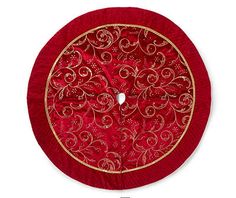 a round red and gold decorative object on a white background with an embroidered design in the center