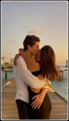 a man and woman embracing on a dock