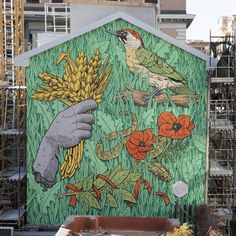 a large mural on the side of a building with flowers and birds painted on it