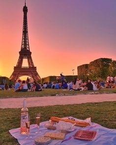 the eiffel tower is in the background as people are sitting and eating outside