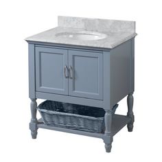 a white sink sitting next to a gray cabinet with drawers and a basket under it