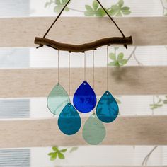 three blue and green tears hanging from a branch