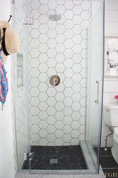 a white tiled bathroom with a walk in shower